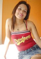 Азиатка позирует на койке в джинсовой юбке 2 фотография